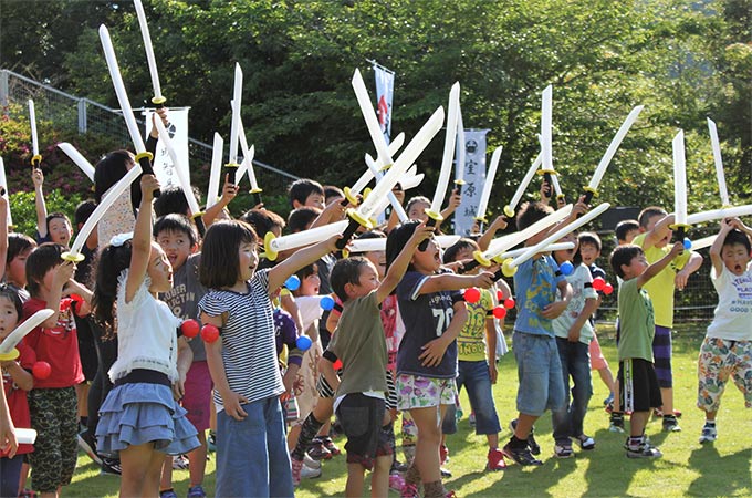 刀を前に突き出している参加者たち