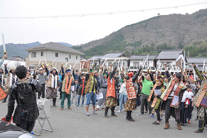 刀を空に突き出している参加者たち